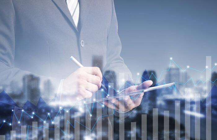 double exposure businessman using digital tablet by graph cityscape